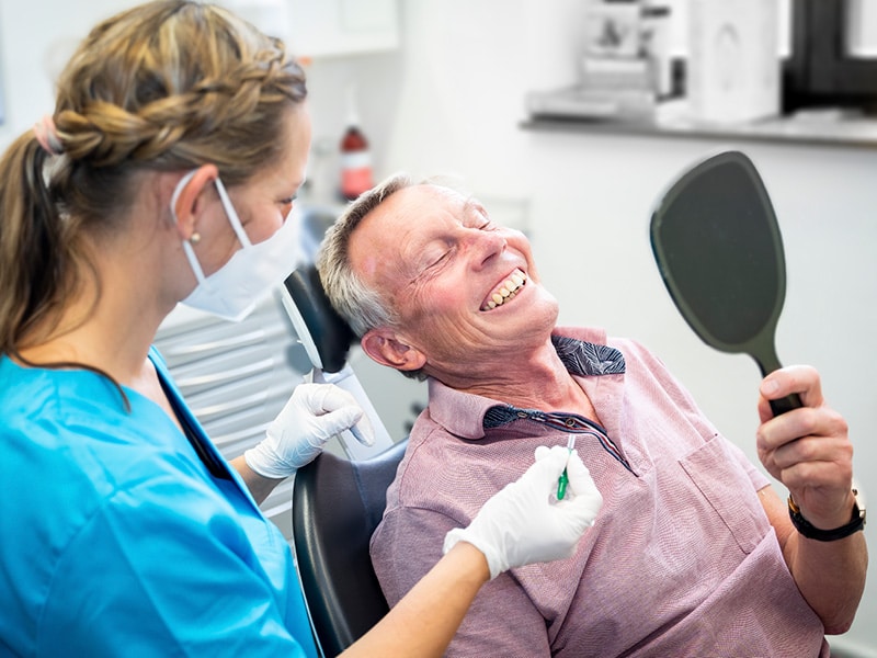 Zahnarzthelferin und Patient bei der medizinischen Zahnpflege